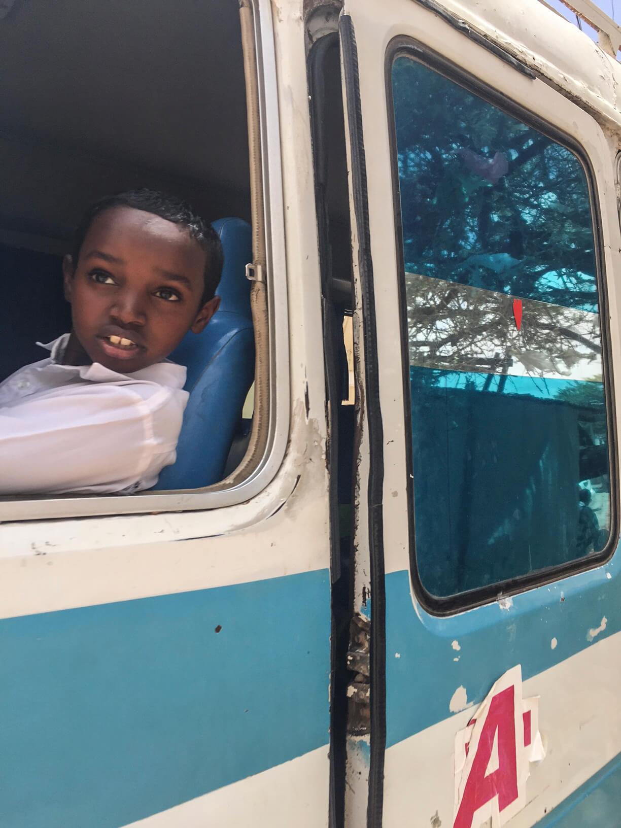 A photo of a pupil looking from the window of a school bus